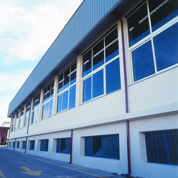 Vista esterna delle vetrate di chiusura capannone con parte fissa e parte scorrevole