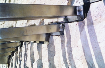 Scala in acciaio inox e cristallo blindato con montaggio su parete in pietra e gradino singolo